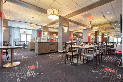 a dining room with tables and chairs in a restaurant at Best Western Plus Paris Orly Airport in Rungis