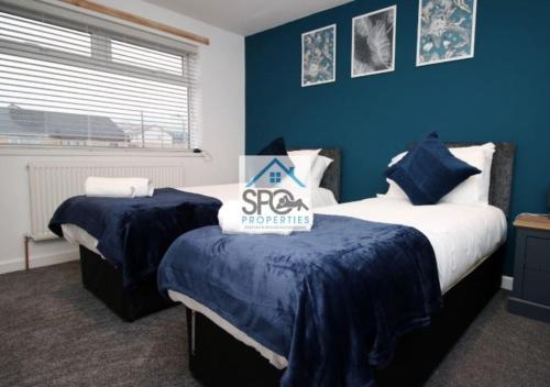 a bedroom with two beds with blue walls at Modern 3BR Home-5 Guests-Business-Families-Netflix-Free Parking & WiFi in Cefn-coed-y-cymmer