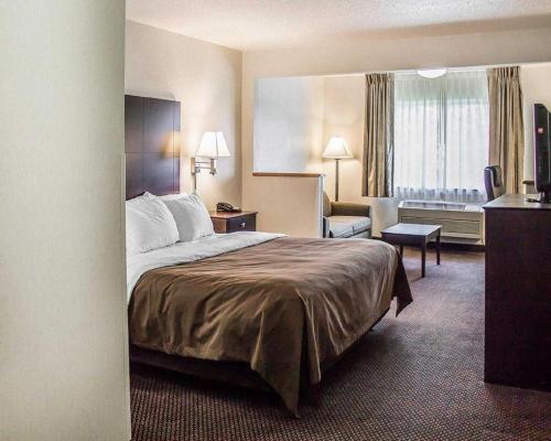 a hotel room with a bed and a living room at Quality Inn & Suites in Sturgeon Bay