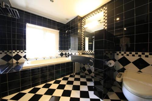 a bathroom with a black and white checkered floor at Lake Hills Sokrisan Hotel in Boeun