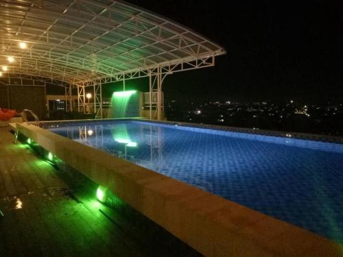 沙馬林達的住宿－Radja Hotel，一座游泳池,在晚上在一座建筑的顶部