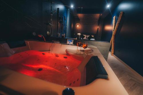 Love Room L'Aixtase - Oasis Romantique à Aix-les-Bains في إيكس لي بان: حمام مع حوض احمر مع حوض