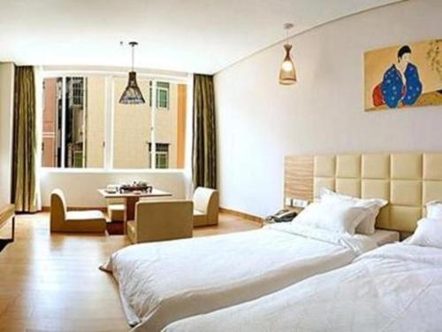 ein Schlafzimmer mit 2 Betten und ein Wohnzimmer in der Unterkunft Orient Sunseed Hotel Airport Branch in Fenghuangwei