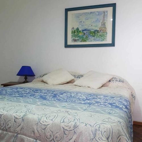 a bed in a bedroom with a picture on the wall at ALPATACAL in Rosario