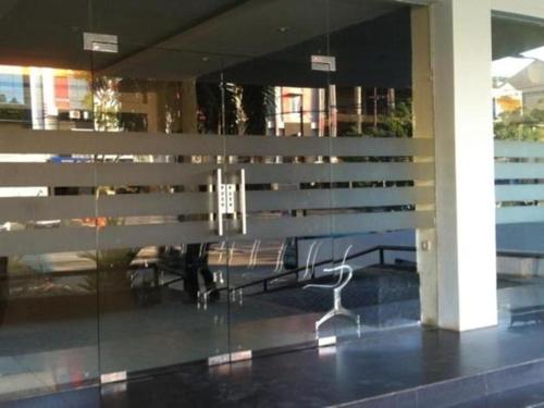 eine Glaswand mit einem Stuhl vor einem Gebäude in der Unterkunft Putri Wisata Hotel in Puunggolaka