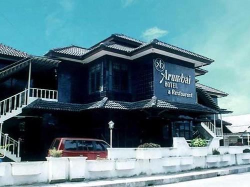 un edificio con un coche aparcado delante de él en Hotel Arumbai en Boruku