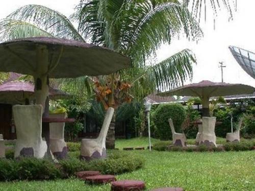 un gruppo di sedie e ombrelloni in un cortile di Hotel Arumbai a Boruku