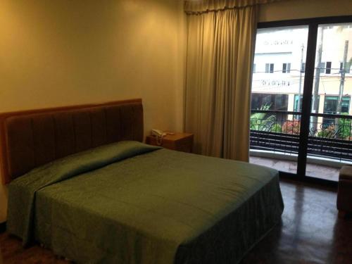- une chambre avec un lit et une grande fenêtre dans l'établissement Bayfront Hotel Subic, à Olongapo