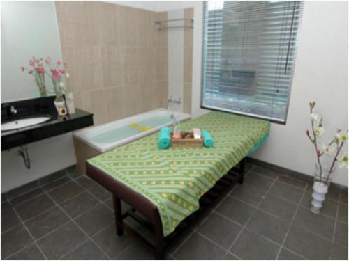 ein Badezimmer mit einer Badewanne und einer Bank mit einem Spielzeug in der Unterkunft Amalia Hotel Lampung in Lampung