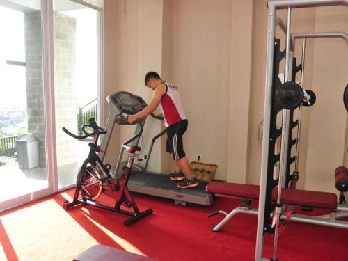 a person standing on a treadmill in a gym at Hotel Minahasa in Manado