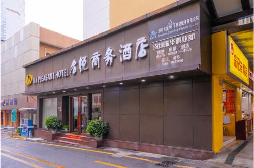 a building with a sign on the side of a street at My Pleasant Hotel in Shenzhen