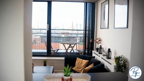 a living room with a couch and a large window at Penthouse - Amazing City Skyline Views - Balcony - FREE extra 2 hours - FREE Parking - Utilita Arena - Bullring Shopping - New St Station- Super King Size Bed in Birmingham