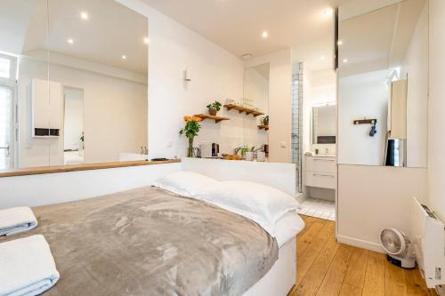 - une cuisine blanche avec un grand lit dans une chambre dans l'établissement PARIS 3° CENTRE MARAIS -COCON CALME (PROPRETÉ +++), à Paris