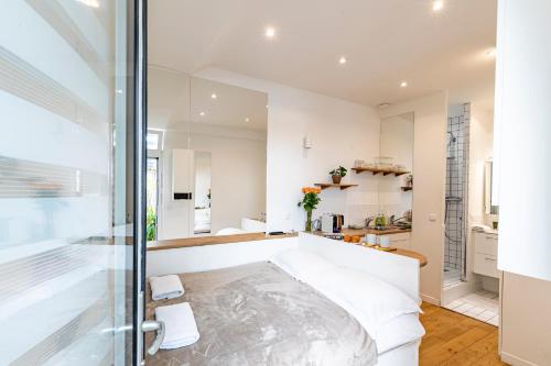 - une chambre avec des murs blancs et un mur en verre dans l'établissement PARIS 3° CENTRE MARAIS -COCON CALME (PROPRETÉ +++), à Paris
