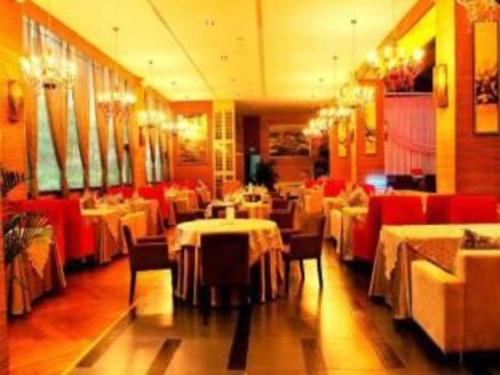 une salle à manger avec des tables et des chaises rouges dans l'établissement Zhoushan Changzheng Spring Hotel, à Liangmaotou