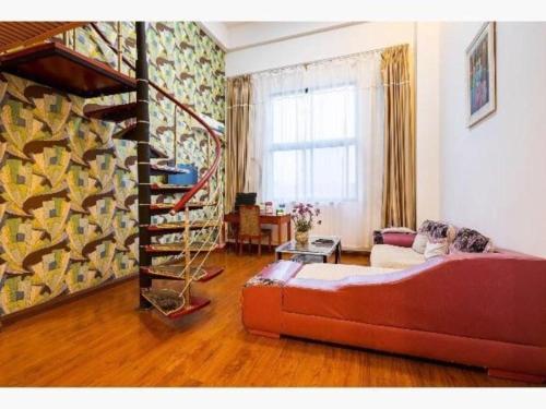 - un salon avec un canapé et un escalier en colimaçon dans l'établissement GreenTree Inn Jiangsu Wuxi Meiyuan Kaiyuan Temple Subway Master Station Express Hotel, à Xuedian