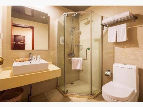 een badkamer met een douche, een wastafel en een toilet bij GreenTree Inn Jiangsu Wuxi Meiyuan Kaiyuan Temple Subway Master Station Express Hotel in Xuedian
