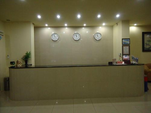 una sala de espera con relojes en la pared en Hotel Makmur en Karanganyar
