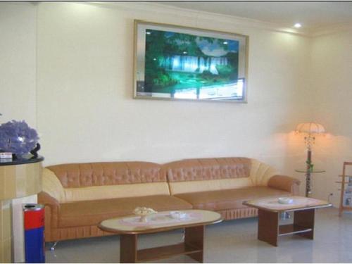 Hotel Makmur في Karanganyar: غرفة معيشة مع أريكة وطاولتين