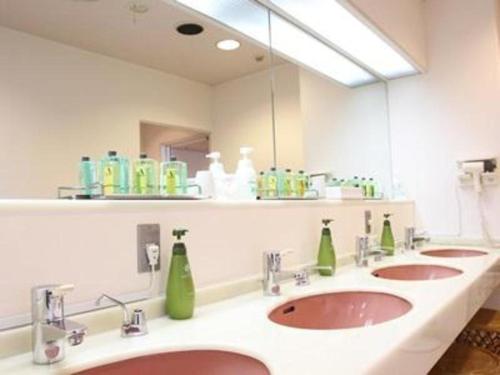 uma casa de banho com 3 lavatórios e um espelho grande em Hotel Akai em Tóquio