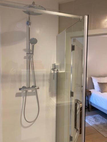 a shower in a bathroom next to a bed at Miranius Rey in Lede