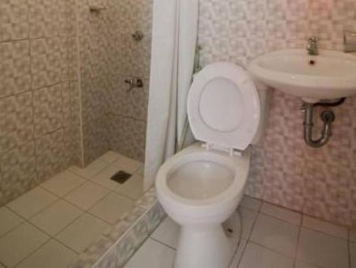 łazienka z toaletą i umywalką w obiekcie Asog County Hotel w mieście Iriga City