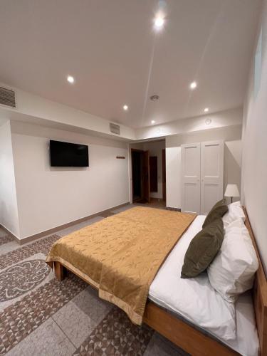 a bedroom with a bed and a tv on a wall at CATHEDRAL Old Town Suites in Vilnius