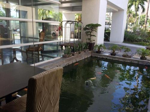 Una casa con un estanque con cometas. en East Asia Royale Hotel en Lagao
