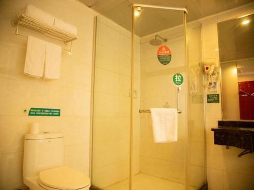 a bathroom with a shower with a toilet and a sink at GreenTree Inn Bozhou Weiwu Road Hotel in Bozhou