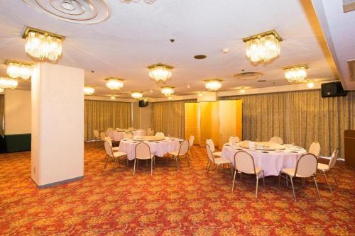 a banquet hall with white tables and chairs at Oita Century Hotel in Oita