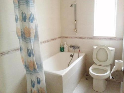 a bathroom with a toilet and a tub and a sink at Man Va Hotel in Macau
