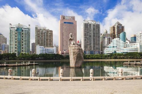 a statue in the middle of a lake in a city at Super 8 Hotel Xiamen Railway Station in Xiamen