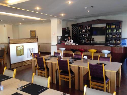 奧隆阿波的住宿－Grand Hoyah Hotel，一间带桌椅的餐厅和一间酒吧
