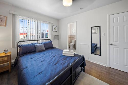 ein Schlafzimmer mit einem blauen Bett und einem Fenster in der Unterkunft Cozy 1 Bd Apt minutes walking downtown Ferndale in Ferndale