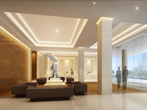 a statue in a lobby with people in a building at Hotel Leader Changsha in Yangtianhu