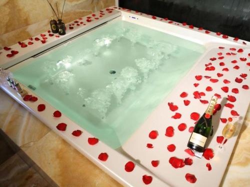 a bath tub filled with flowers and a bottle of champagne at Hotel Leader Changsha in Yangtianhu