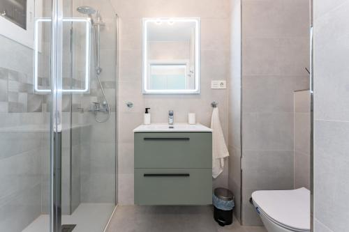 a white bathroom with a sink and a shower at Apartamento Aguila 05 in Benalmádena