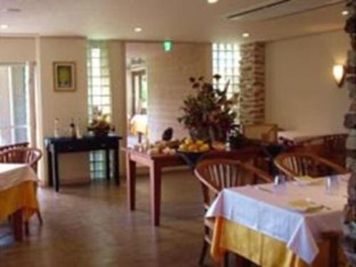 a dining room with two tables and chairs and a table with fruit at Hotel Shikino Kura in Kawazu