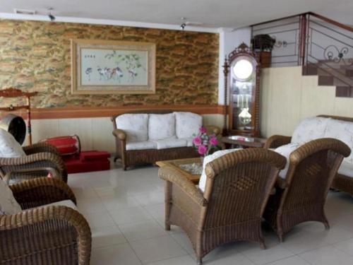 uma sala de estar com cadeiras de vime e uma mesa em Jelita Hotel em Banjarmasin