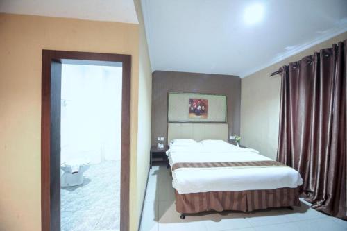 een slaapkamer met 2 bedden en een groot raam bij New Hollywood Hotel in Pekanbaru