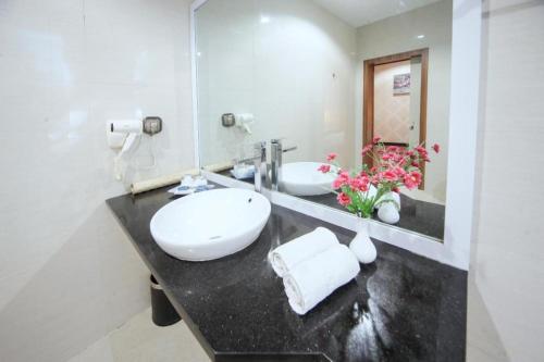uma casa de banho com um lavatório e um espelho em New Hollywood Hotel em Pekanbaru