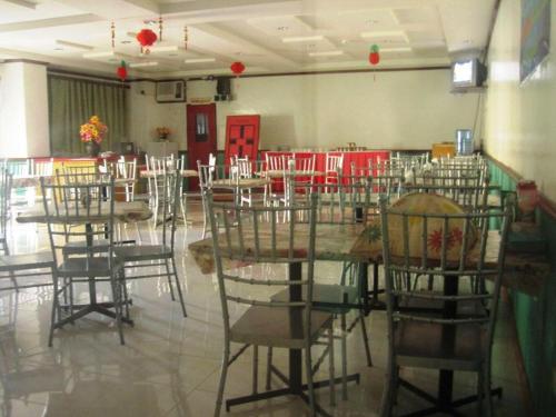 a dining room with tables and chairs and red doors at Magayon Hotel in Buenavista
