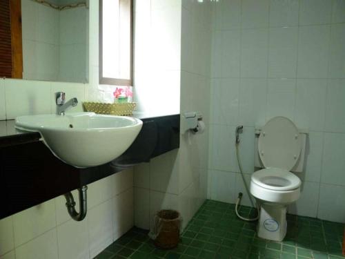 Un baño con lavabo, inodoro y ventana. en Cha Am Villa Beach, en Ban Bo Khaem