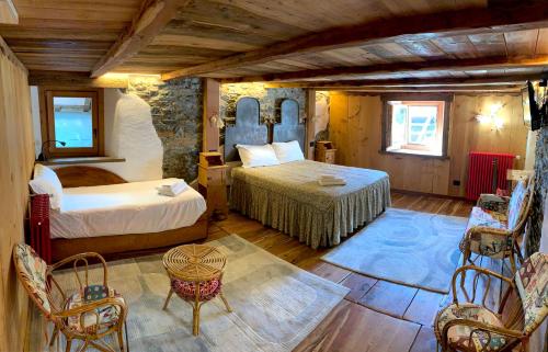 um quarto com 2 camas, uma mesa e cadeiras em Chalet del Lago em Ceresole Reale