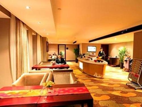 um lobby de um hotel com pessoas sentadas no lobby em Jincheng Pacific Hotel em Jingcheng