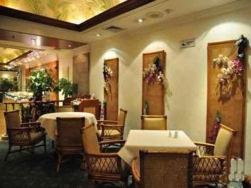 un comedor con mesas y sillas en un restaurante en Zhengzhou Yiquan International Hotel, en Zhengzhou