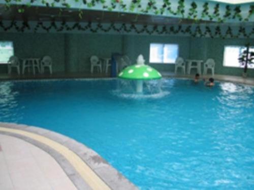 uma piscina com uma fonte no meio dela em Jincheng Pacific Hotel em Jingcheng