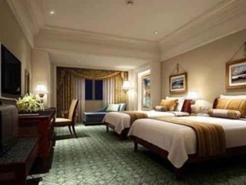 Habitación de hotel con 2 camas y escritorio en Zhengzhou Yiquan International Hotel, en Zhengzhou
