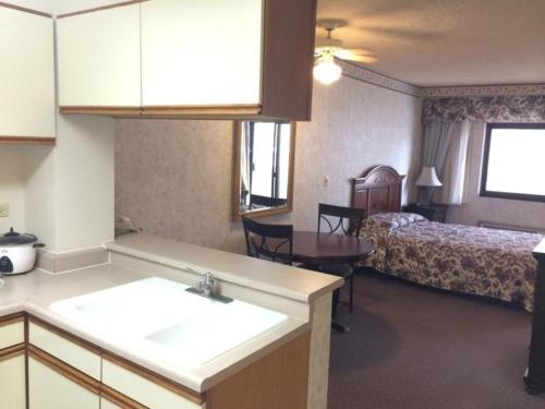 ein Hotelzimmer mit einer Küche und einem Schlafzimmer in der Unterkunft Guam Airport Hotel in Tumon