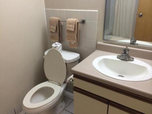 ein Bad mit einem WC und einem Waschbecken in der Unterkunft Guam Airport Hotel in Tumon